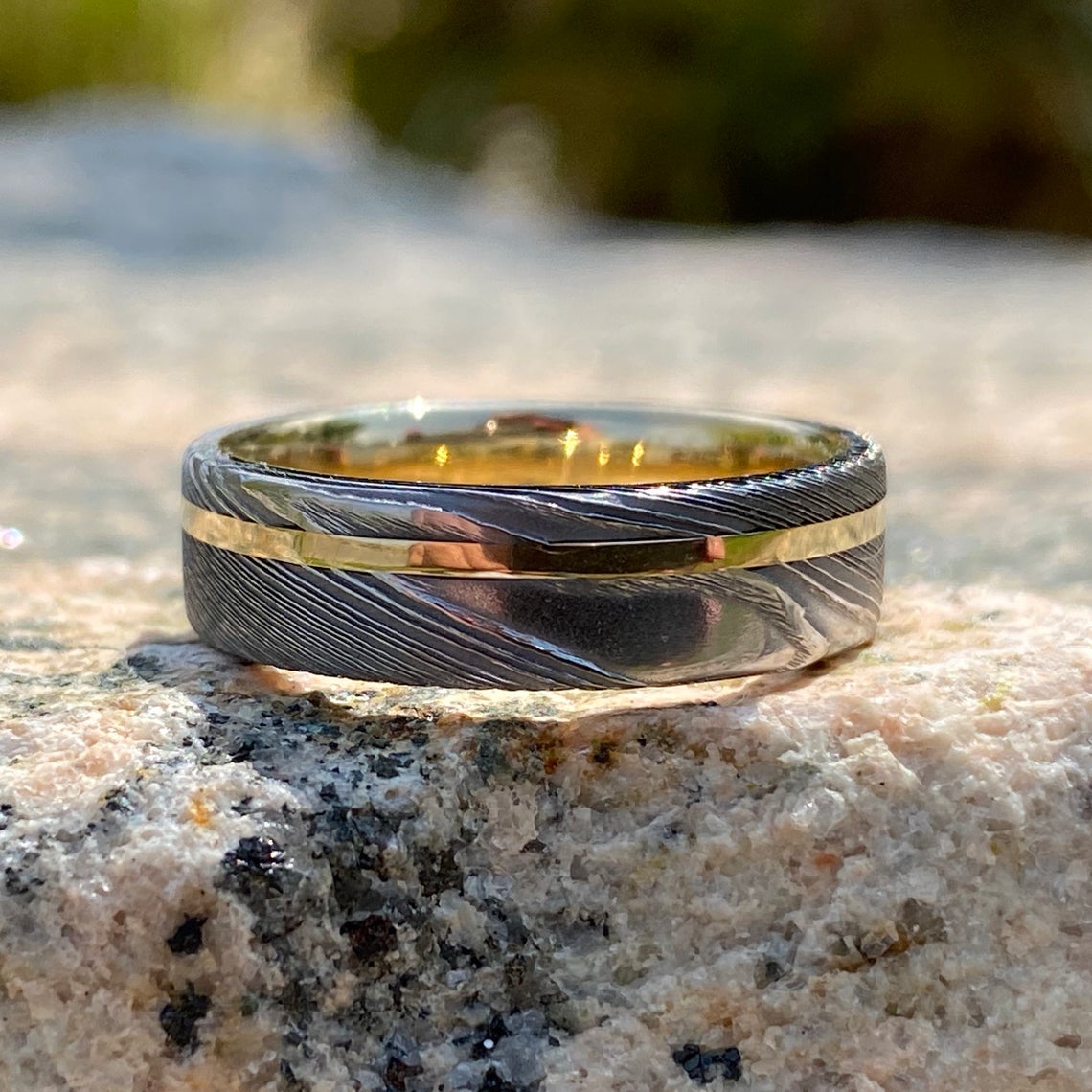 6mm wide white Damascus steel ring with a 14k yellow gold off-center inlay and sleeve
