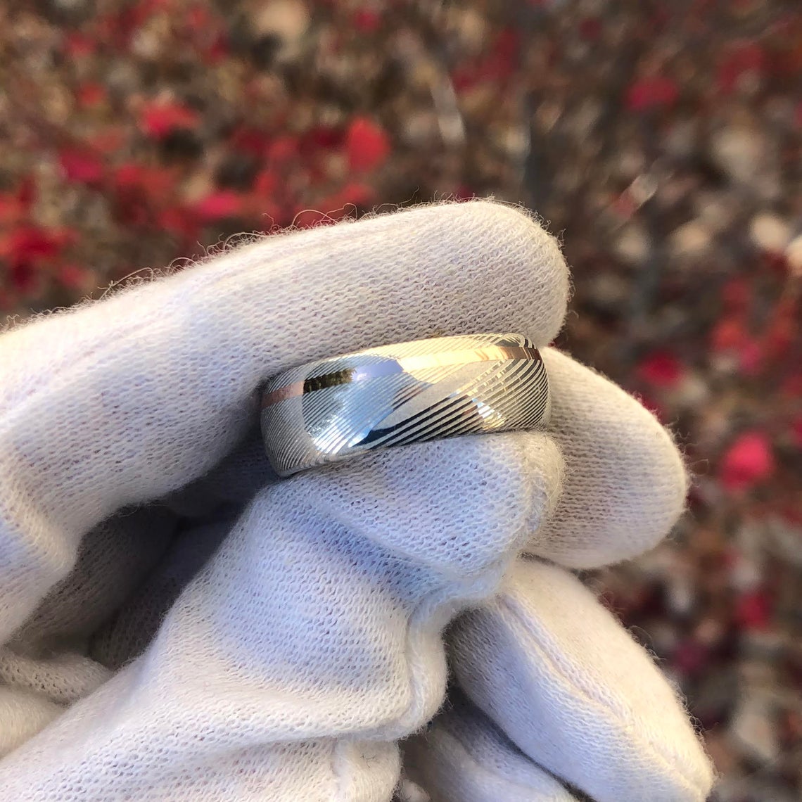 8mm wide white Damascus steel ring with an off-centered rose gold inlay and rounded profile