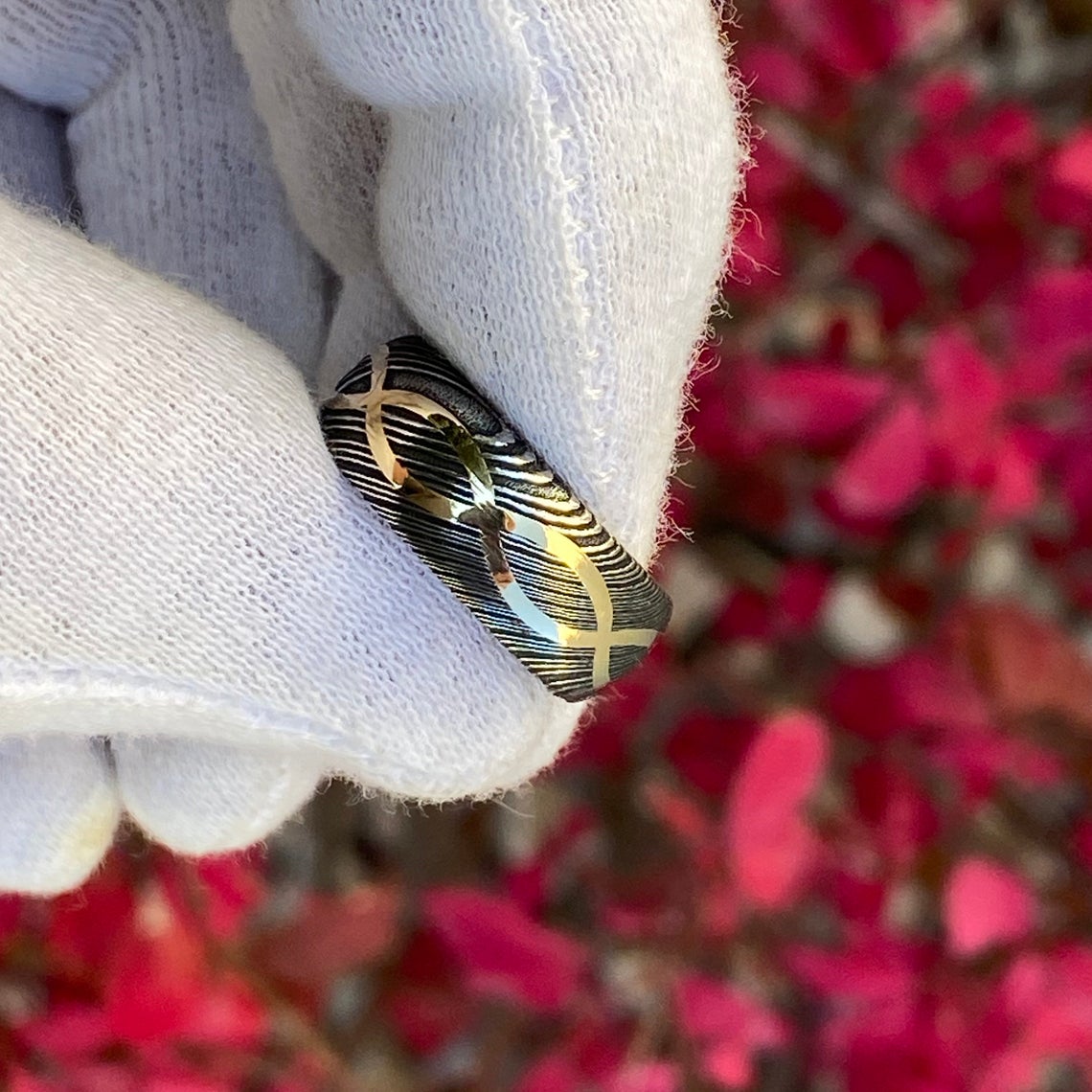 8mm wide Black Damascus steel ring with a 14k yellow gold infinity inlay