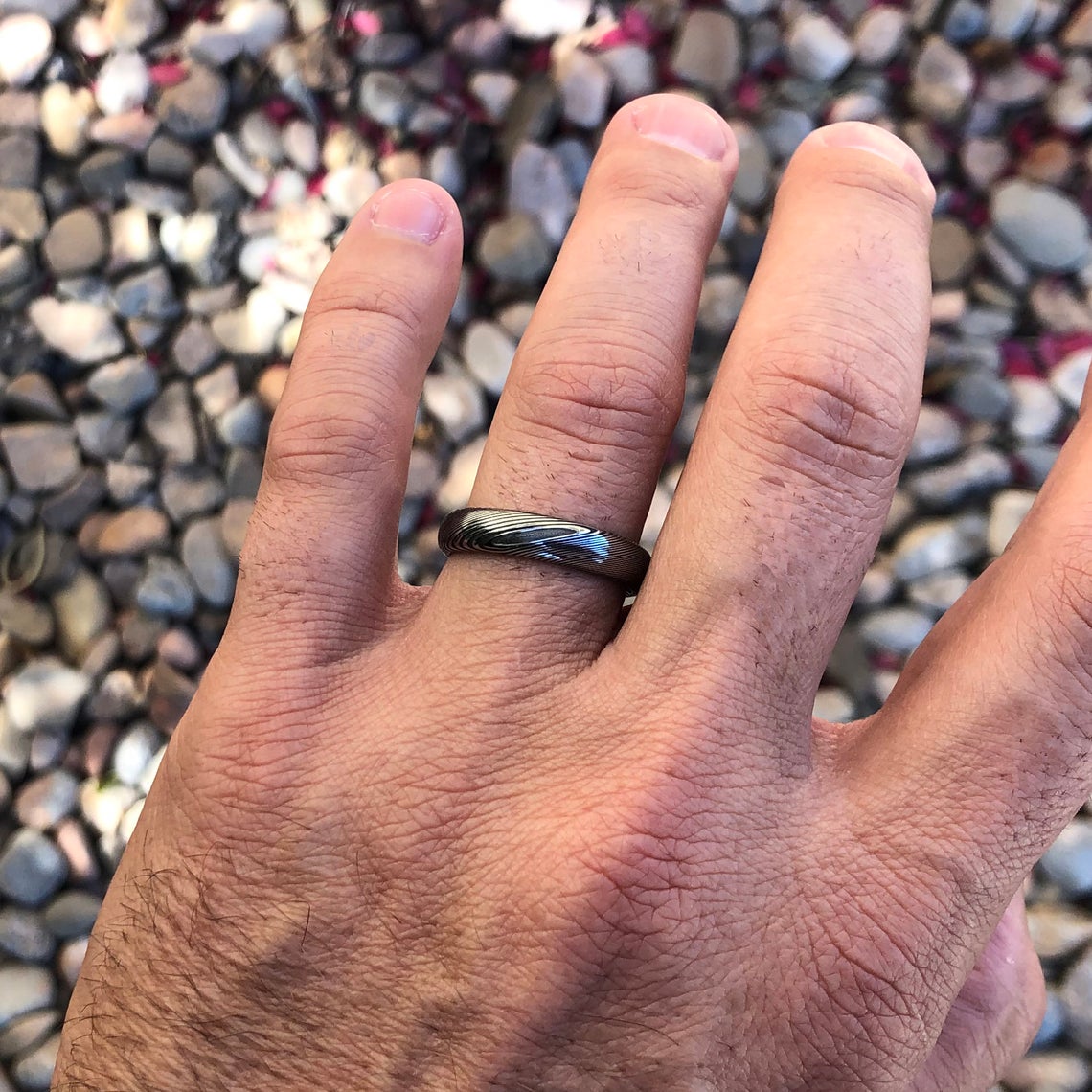 5mm wide Damascus steel wedding band on man&#39;s hand
