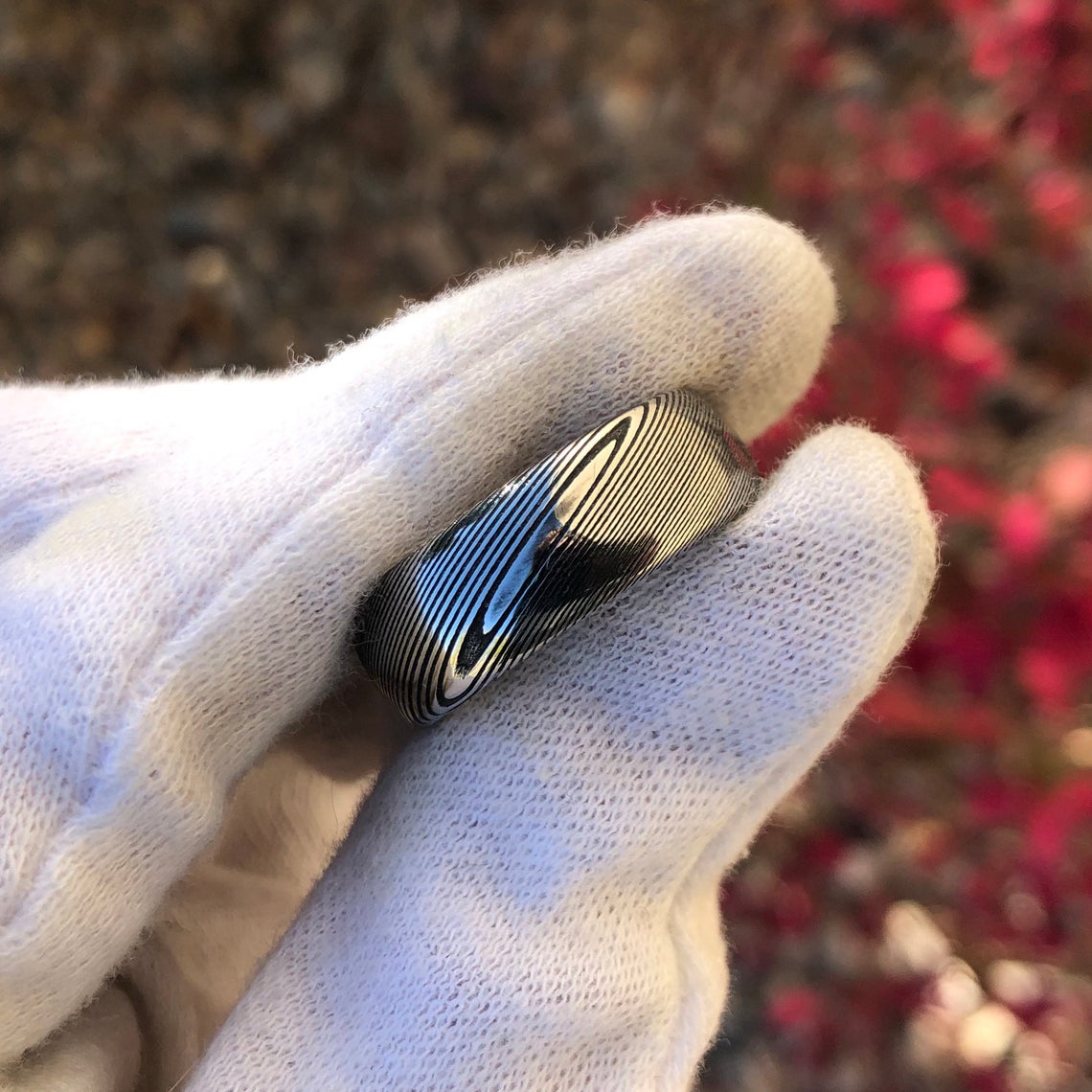 8mm wide Damascus steel wedding band with a rounded profile held by a white glove