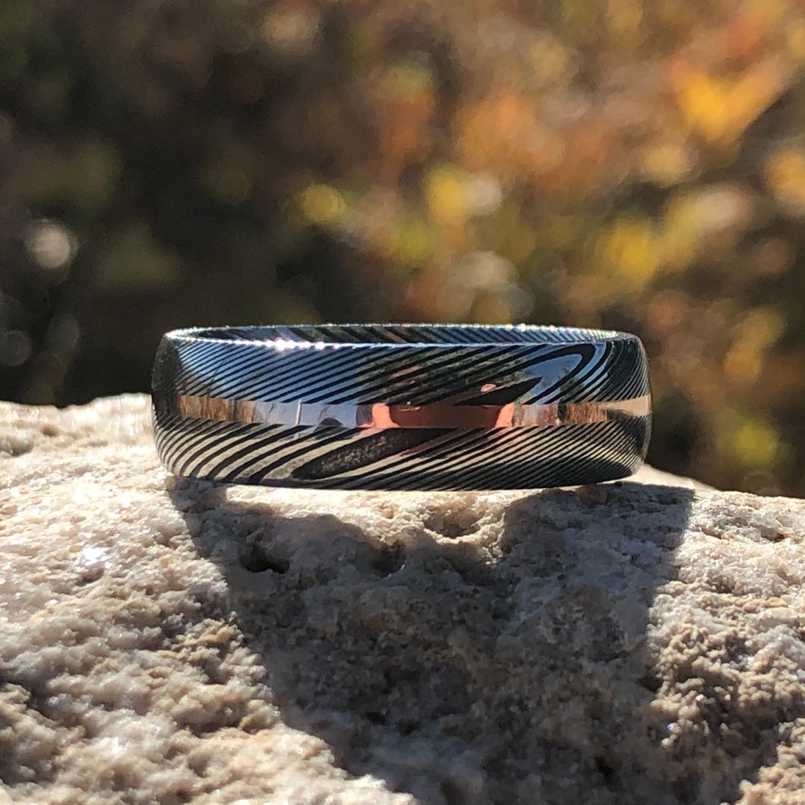 7mm wide Damascus steel ring with a centered rose gold inlay