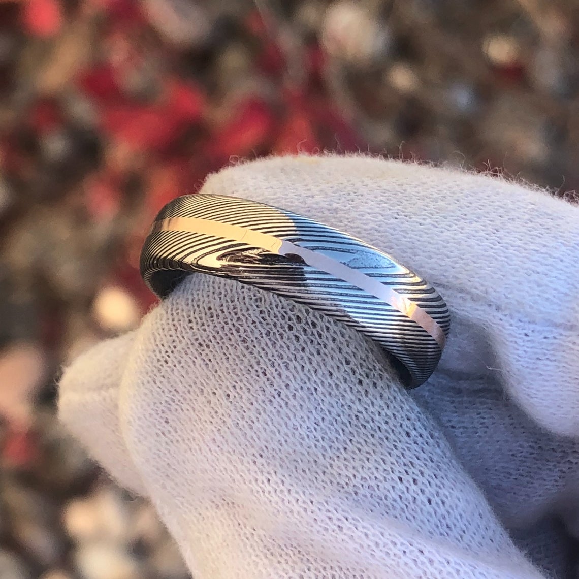 6mm wide Damascus steel ring with a centered rose gold inlay and a rounded profile